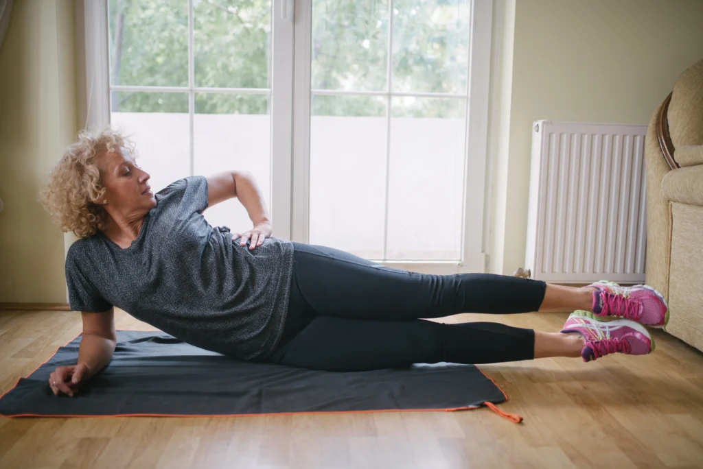 Woman performing a hip exercise on an exercise mat.